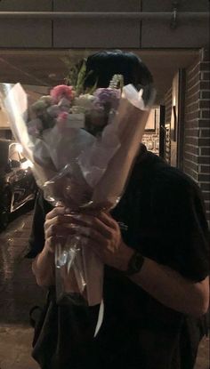 a man holding a bunch of flowers in his hands