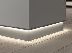 an empty room with wooden floors and white walls, illuminated by leds in the corner