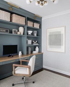 a home office with built - in shelving units and wicker baskets on the shelves