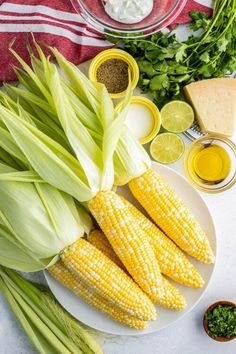 corn on the cob and other ingredients laid out on a white plate with a red striped towel