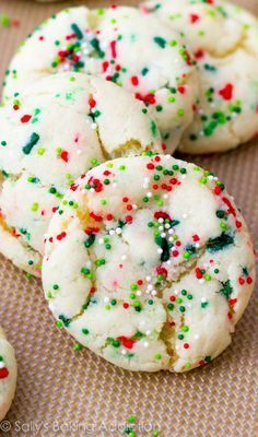 white sugar cookies with sprinkles are on a baking sheet and ready to be eaten