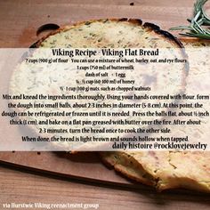 a piece of bread sitting on top of a wooden cutting board next to a sprig of rosemary