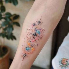 a woman's arm with stars and planets on it