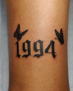 a woman's tattoo with butterflies and the number 999 on her lower leg