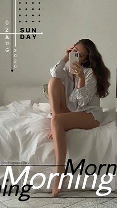 a woman sitting on top of a bed holding a cell phone