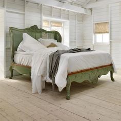 a bed sitting in the middle of a room next to a window and a ladder