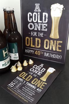 two bottles of beer next to a birthday card and some chocolates on a table