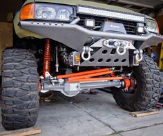 an off road vehicle is parked in a garage with its front bumpers lifted up