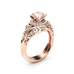 a rose gold engagement ring with an oval center stone surrounded by intricate filigrees