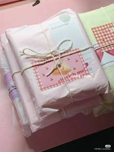 three wrapped presents tied up on top of each other in pink and green wrapping paper