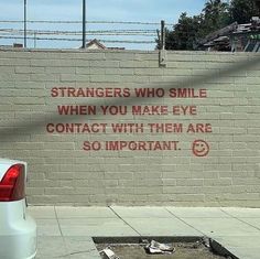 a white truck parked next to a brick wall with graffiti on it's side