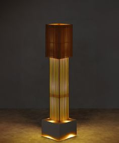 a tall lamp that is lit up in the dark with dim lighting on it's sides