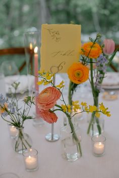 there are many vases with flowers in them on the table and one has a note attached to it