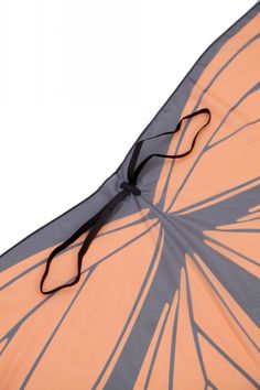 an orange and grey kite with black straps