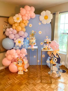 a room filled with balloons and decorations on top of hard wood flooring next to a window