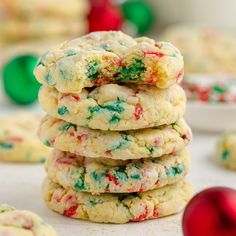 a stack of cookies with sprinkles next to a red ornament