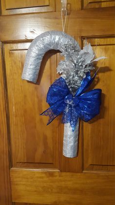 a door hanger decorated with silver and blue ribbons