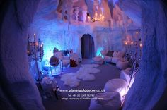 a living room filled with lots of white furniture and lights in an ice cave like setting