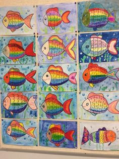 colorful fish are painted on paper with watercolors and then placed in squares to make them look like they're swimming