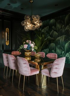 a dining room table with pink chairs and gold accents