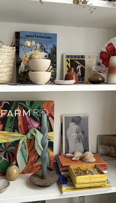 two shelves with books and vases on them