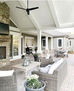 an outdoor living area with couches, chairs and a table in front of a fireplace