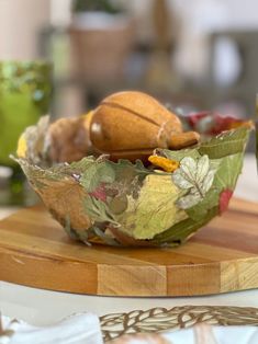 a wooden table topped with a bowl filled with fruit