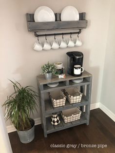 there is a shelf with plates and cups on it next to a potted plant