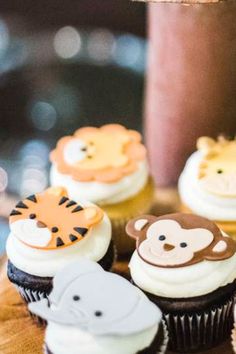 several cupcakes decorated with different types of animals