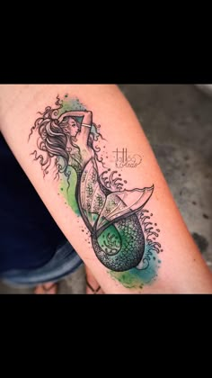 a woman's arm with a tattoo on it and an image of a mermaid