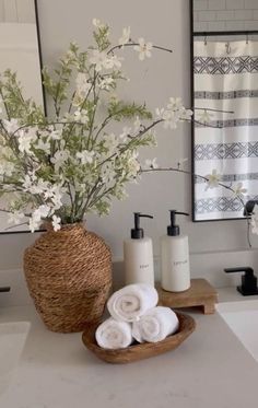 a bathroom with white towels and flowers in a basket