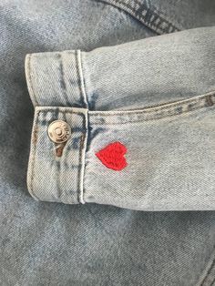 a pair of jeans with red heart patches on them