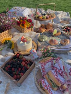 an outdoor picnic with food and snacks on the table in front of it, including cake