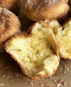 some sugared doughnuts are sitting on a table