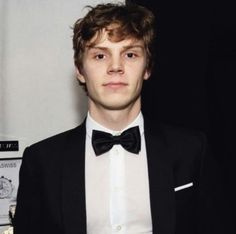 a young man wearing a tuxedo and bow tie