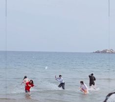 several people are playing in the water at the beach