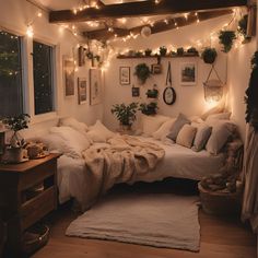 a bedroom with lights strung from the ceiling and blankets on the bed in front of it