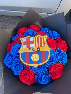 a bouquet of red, white and blue roses in front of a soccer emblem on the side of a car