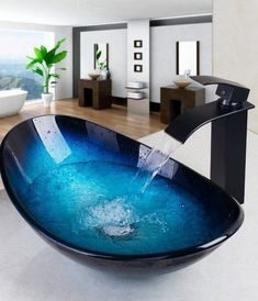 a bowl shaped sink with blue water running from the faucet to it's side