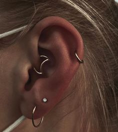 a close up of a person's ear with two piercings on top of it