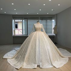 a white wedding dress on display in front of a window