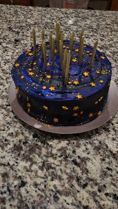 a blue cake with gold stars on it sitting on top of a granite countertop