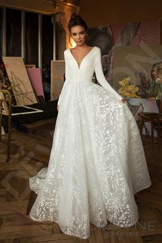 a woman in a white wedding dress standing on a wooden floor with her hands on her hips