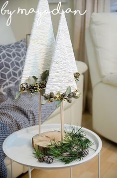 two white christmas trees sitting on top of a table