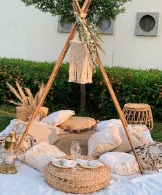 a table topped with lots of pillows and blankets next to a tree filled with oranges