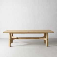 a wooden table sitting on top of a white floor covered in light colored wood furniture