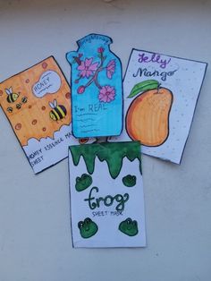 four cards with different designs on them sitting on top of a white surface, one has a jar and the other has an orange