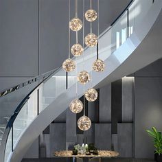 a modern chandelier hangs from the ceiling above a dining room table and chairs