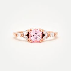 Custom designed by Amelie, and exclusive to Identity Diamonds Recycled metal Set in the center with a lovely 1.25ct* (6mm) cushion cut lab-grown rosé sapphire With a blush hue reminiscent of the color of morganite, our rosé sapphire features a slightly more saturated pink, and it offers a much better durability than morganite, making it ideal for an engagement ring! Available in two different tones: a hint of peach, or a hint of lavender in it Features six marquise shaped lab-grown diamonds, for Rose Gold Cushion Cut Ring With Accent Stones, Rose Gold Square Cut Promise Ring, Rose Gold Rings With Asscher Cut And Accent Stones, Rose Gold Square Cut Wedding Rings, Spinel Engagement Rings, Montana Sapphire Engagement, Montana Sapphire Engagement Ring, Engagement Ring Pictures, Gold Color Combination