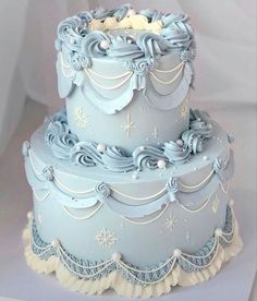 a three tiered blue cake with frosting decorations